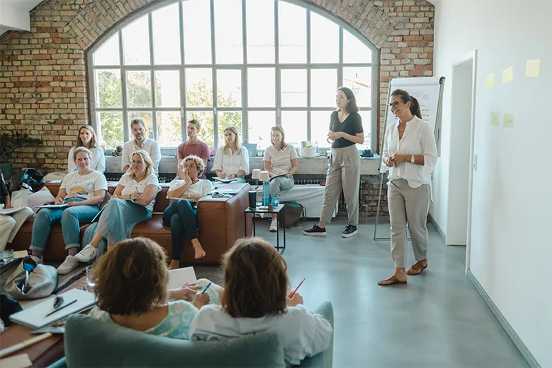 Teilnehmerinnen verfolgen eine Präsentation