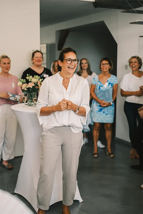 Frau spricht und lacht vor einer Gruppe